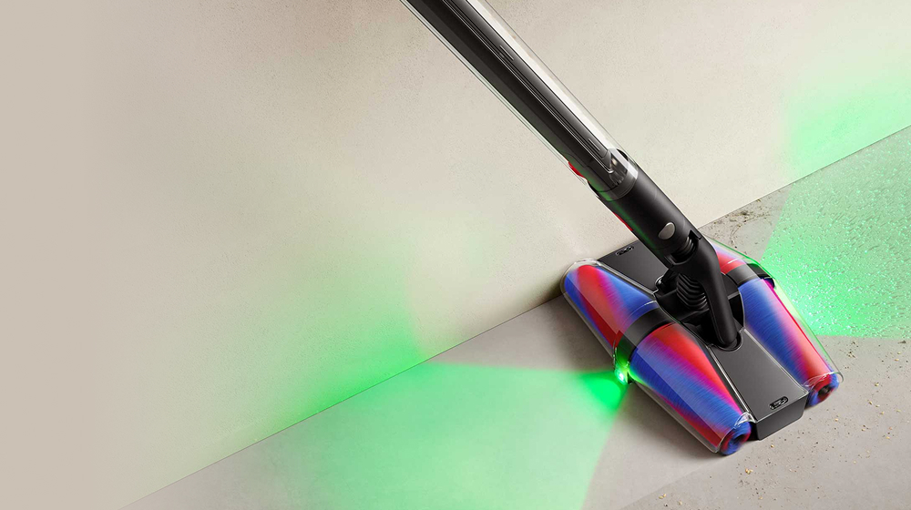 The Fluffycones cleaner head on the Dyson PencilVac vacuum cleans dust and debris from a floor.