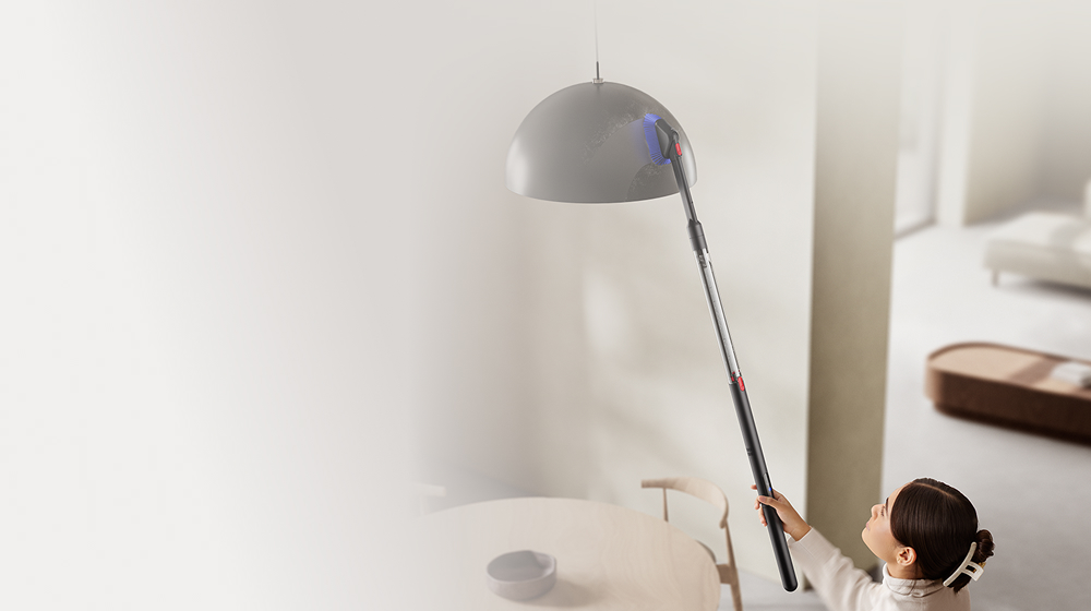 The Dyson PencilVac vacuum is used with the Rotating combi-crevice tool to clean a lampshade.